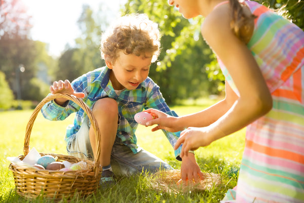 Two kids searching for eggs during an Easter egg hunt