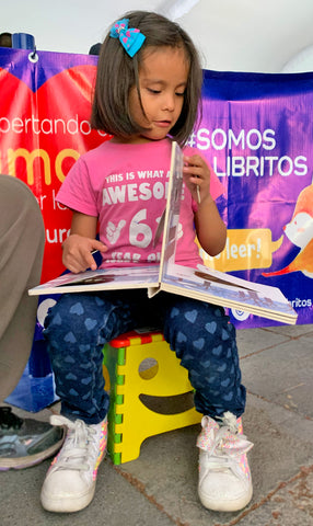 Niños leyendo libros en la feria del libro 