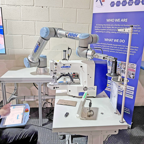 Robot arm interacting with a sewing machine