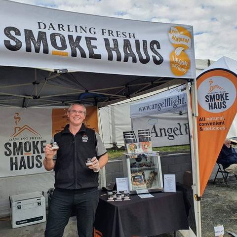 Jeff Schultheiss holding jars of Wood-Smoked Seasonings at the DF Smoke Haus stall at FarmFest 2022