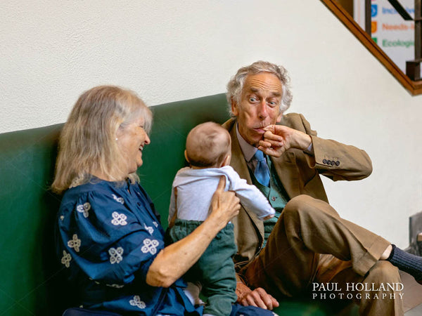 Image show grandparents playing with their grandchild