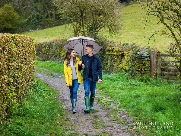 Image showing a couple under an umbrella walking on a rural lane