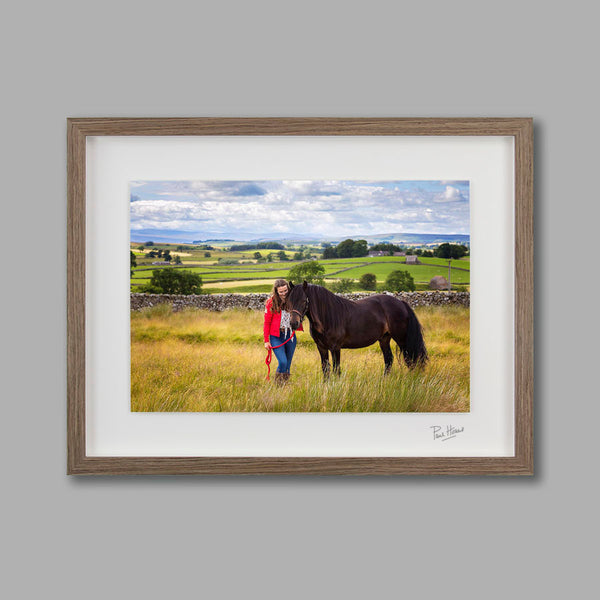An outdoor portrait of a horse and rider in a brown frame