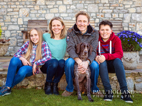 Outdoor photo showing a family with their dog
