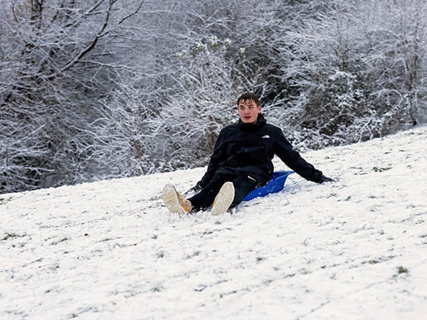 Blue on a blue sledge going downhill