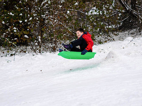 Image shows a young boy on an airborne sledge