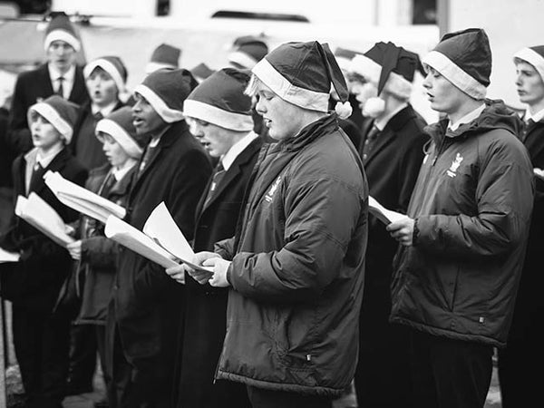 a black and white image showing a group of carol singers
