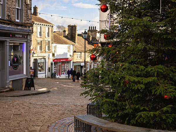 Image shows part of Kendal Christmas tree and a cobbled street