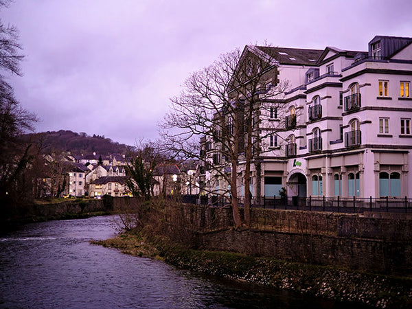 Acolour photo of K Village building at dusk and bathed in purple evening light