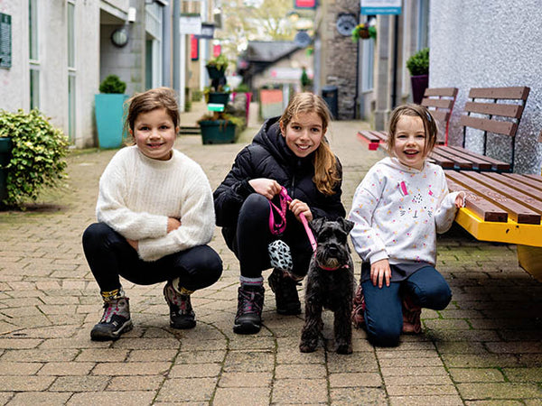 Image shows three children and their pet dog