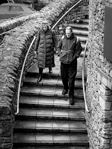 Black and white image of a couple descending a flight of stairs