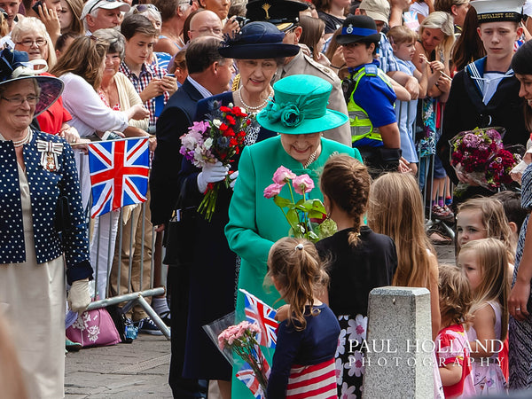 Image shows Queen Elizabeth II receiving flowers from school children