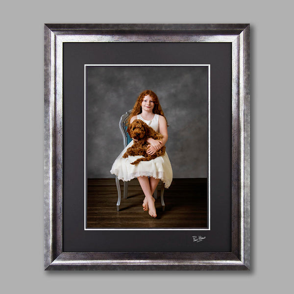 Fine art image of a girl and her dog set in a large silver frame