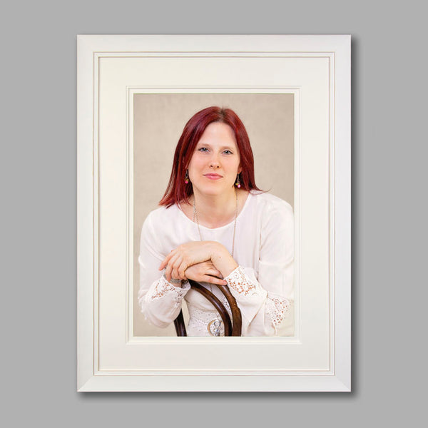 Image shows a studio portrait of a woman set in a cream coloured frame