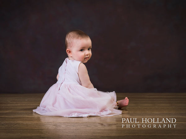 Portrait image of a young toddler sitting on the floor