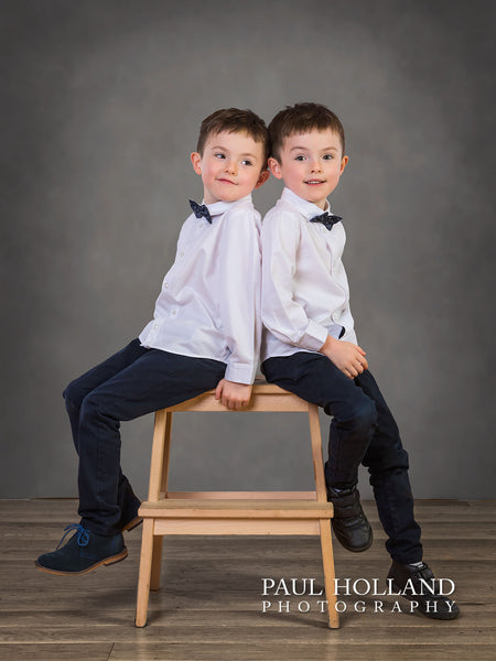 A studio portrait image by Paul Holland showing identical twin boys in the studio.