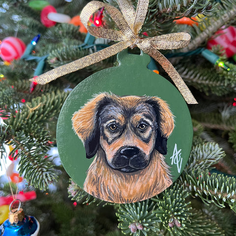 Acrylic painting of a brown and black dog on a Christmas ornament with a green background.