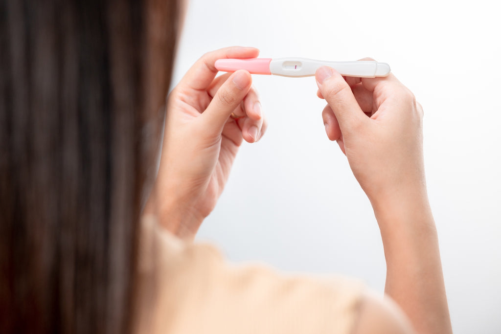 woman looks at negative pregnancy test result