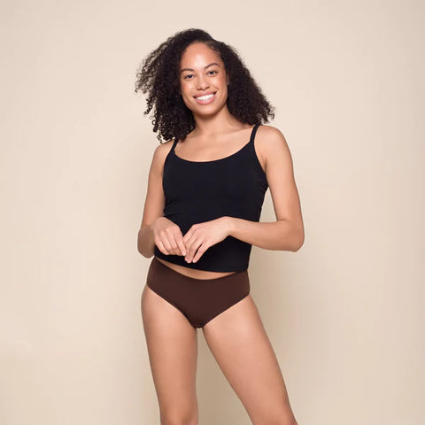 A young woman wearing a black tank top and Ruby Love Hipster Period underwear in Chocolate Opal