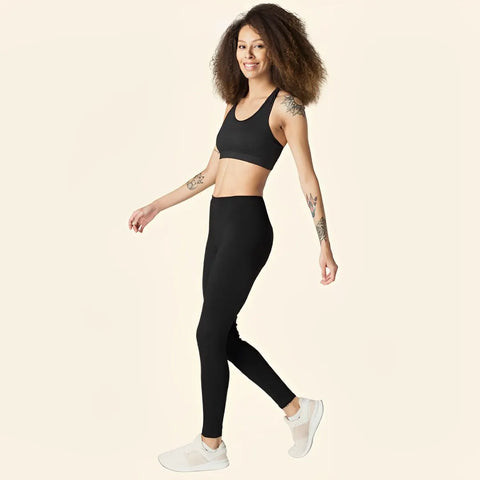 Girl wearing a black sports bra and black leggings with white sneakers