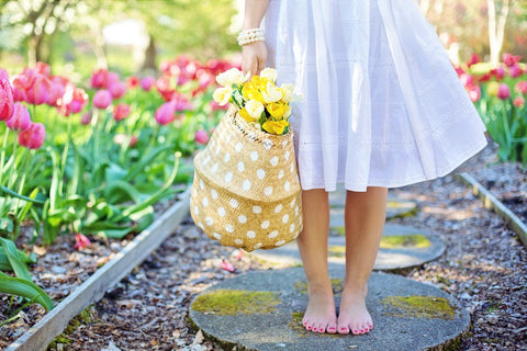 A woman in a white summer dress holding a yellow bag