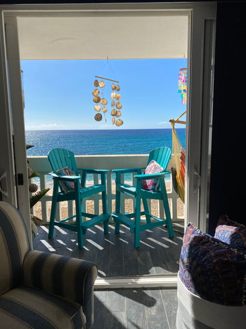 teal tall adirondack chairs on apartment balcony