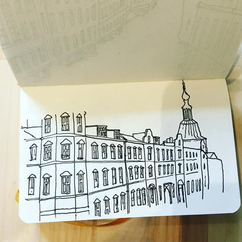 An open sketchbook with a drawing of Copenhagen streets