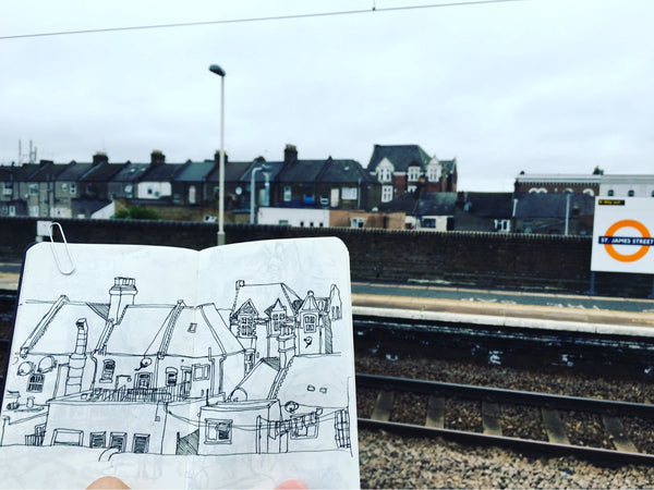 An open sketchbook with a drawing from St James Street Station