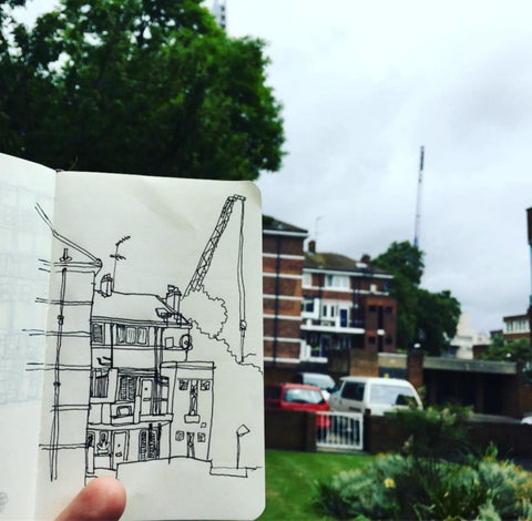 The Kipling Estate in an open sketchbook with the streets and cranes behind