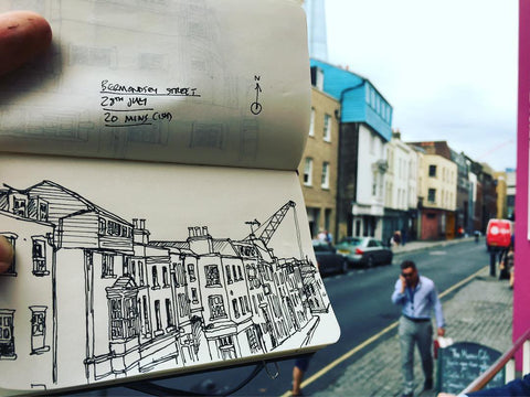 A timed sketch in a sketchbook of Bermondsey Street held up with the view behind