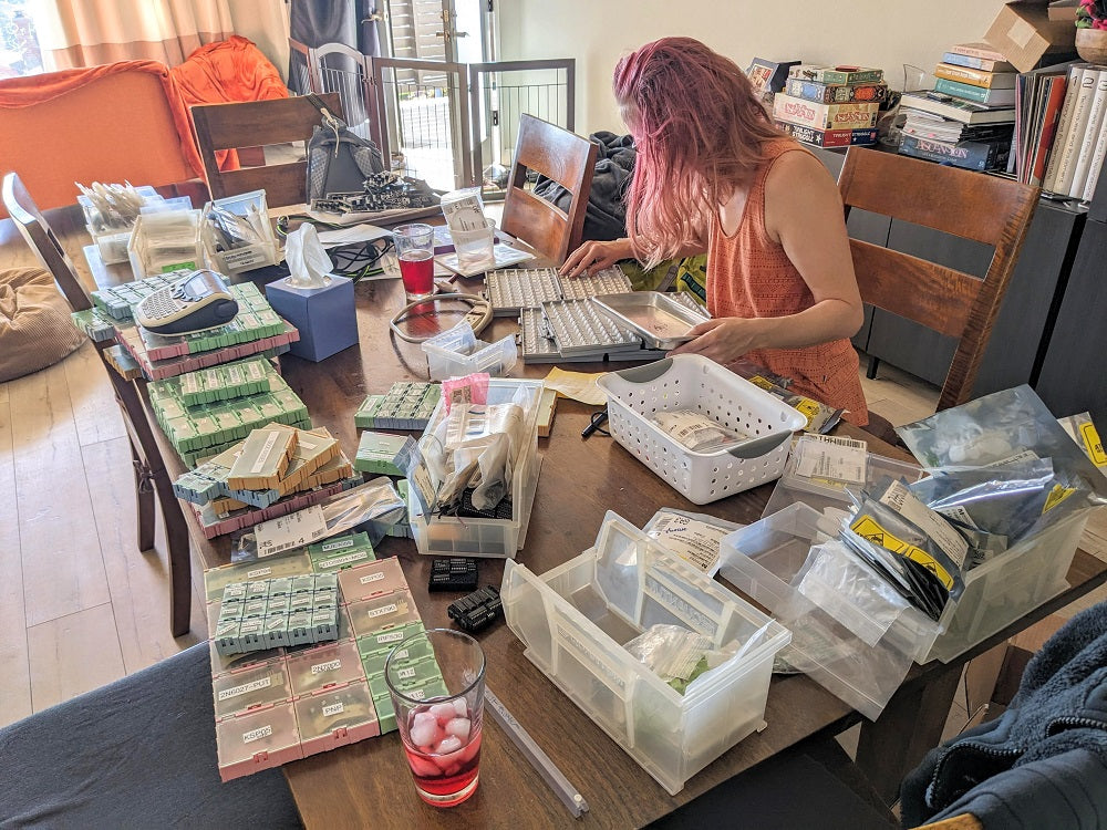 Kris organizing parts into labeled containers on the kitchen table. What's for dinner? Wavefolders, hopefully.