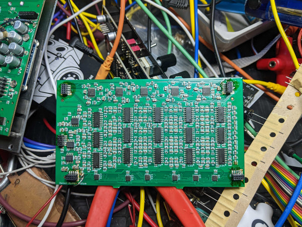 The analog circuitboard of Xer Mixa lying on a bed of cables.