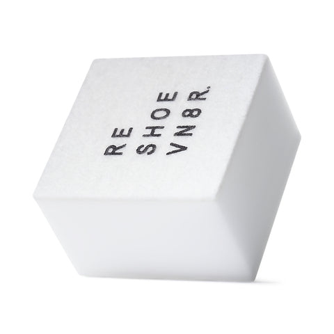 A white shoe cleaning sponge with black text that says "RESHOEVN8R" sitting on a white surface.