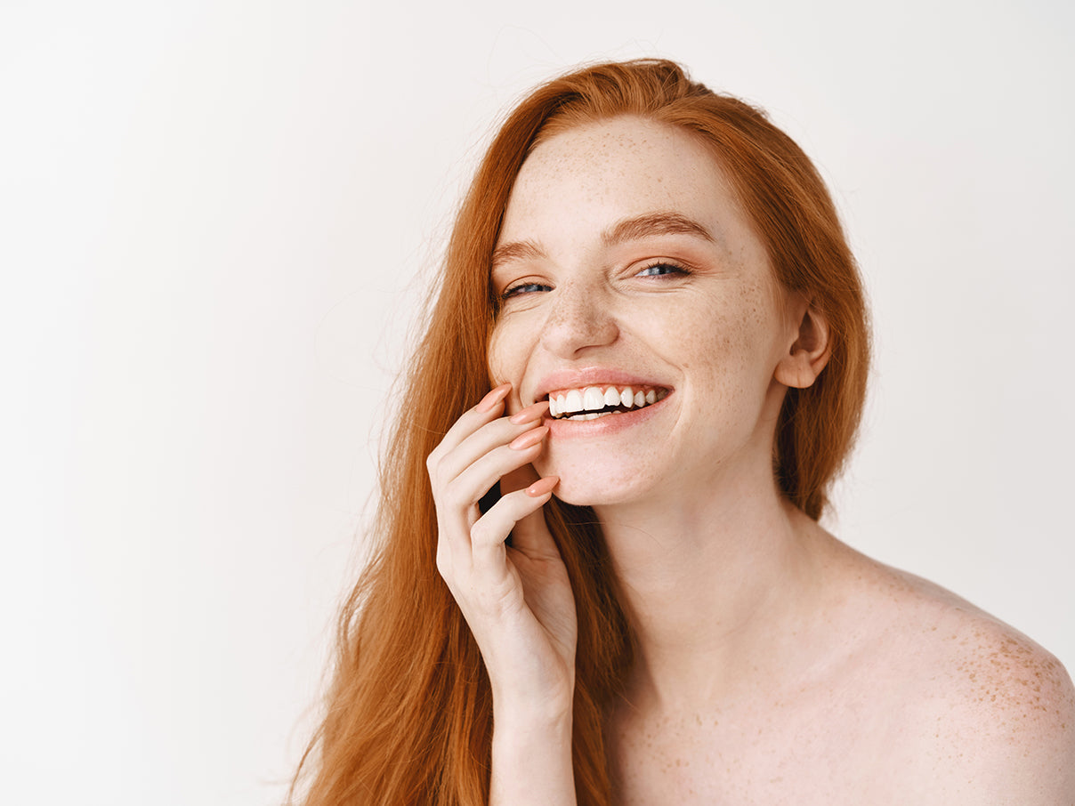 Red haired woman with moisturised skin