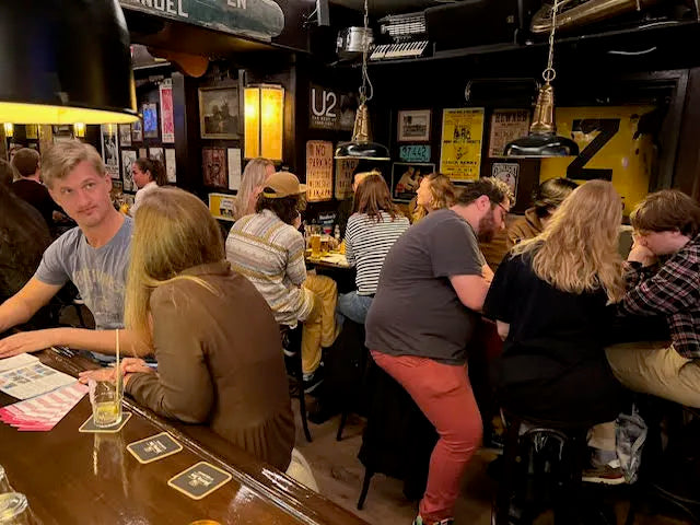 een groep mensen speelt een pubquiz in de kroeg na uitleg te hebben gekregen over wat een pubquiz is en hoe het werkt