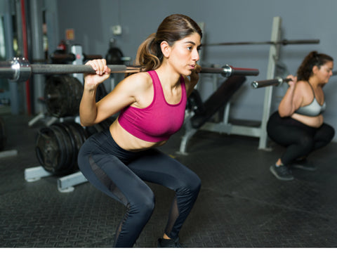 fitness girl squatting with a weight on her back