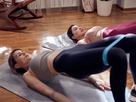 two-fitness-girls-doing-Glute-Bridge-with-Resistance-Band