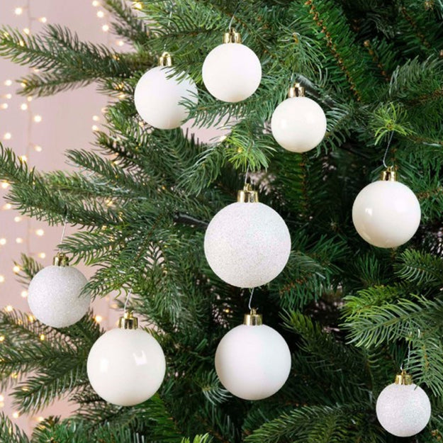 white baubles hanging on a green christmas tree