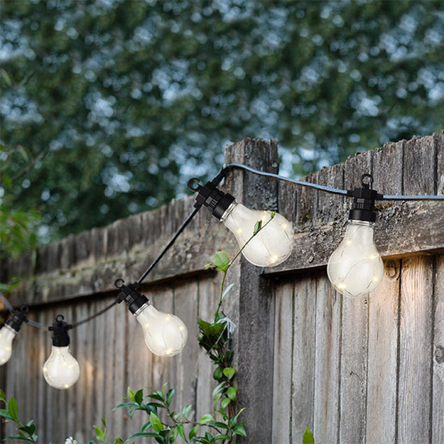 clear festoon garden party lights hung on a fence