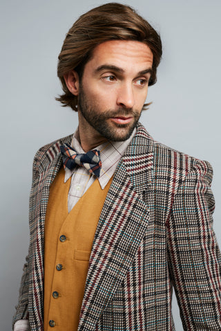 Man in brown plaid suit and yellow vest and bowtie