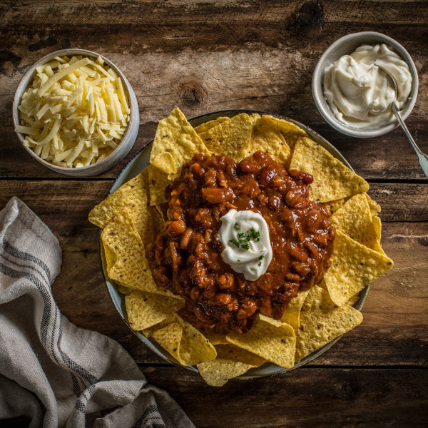 Nachos made with Grant's Mexican Chilli on a wooden table 