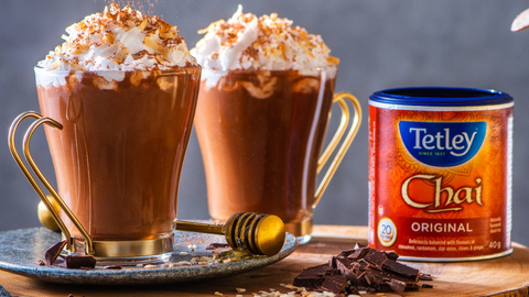 Beautiful food photography: two mugs filled with creamy hot chocolate and topped with coconut whipped cream and chocolate shavings. Recipe made using Tetley Chai tea. 