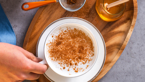 Beautiful food photography: soothing caffeine-free latte served in a large round mug and topped with a dash of cinnamon. Recipe made using Tetley Dream tea. 