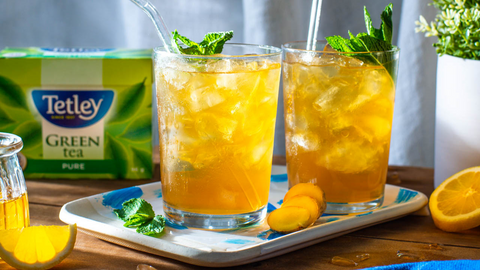 Beautiful food photography: two cups filled with refreshing iced tea and topped with fresh mint leaves. Recipe made using Tetley Pure Green tea. 