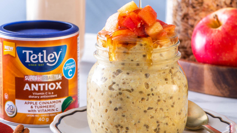 Beautiful food photography: jar filled with overnight oats and topped with apple slices and maple syrup drizzle. Recipe made using Tetley Super Herbal Antiox tea. 