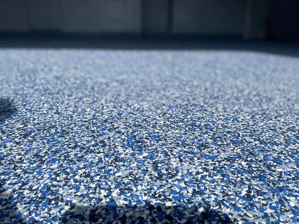 An epoxy flake floor with a blue, black, and white finish.