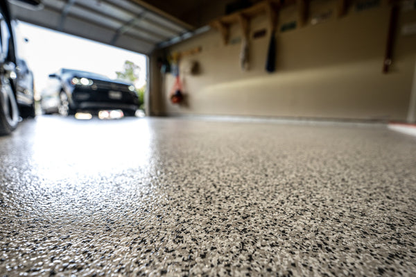 An image of a car parked in a garage that has a flake floor finish.