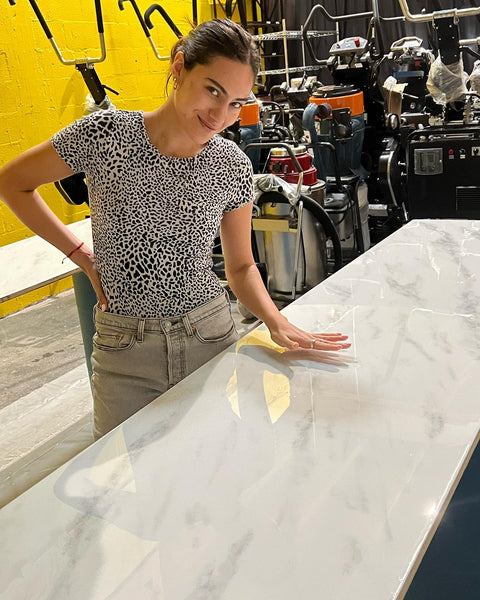 An image of a woman standing over a white and grey metallic epoxy countertop.