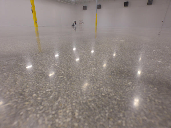 An image of a highly reflective and shiny concrete floor finish inside a commercial warehouse that has just been burnished.