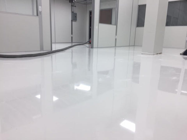 A solid white epoxy floor inside a medical facility.